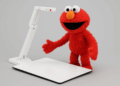 Elmo character using an ELMO document camera in a courtroom setting