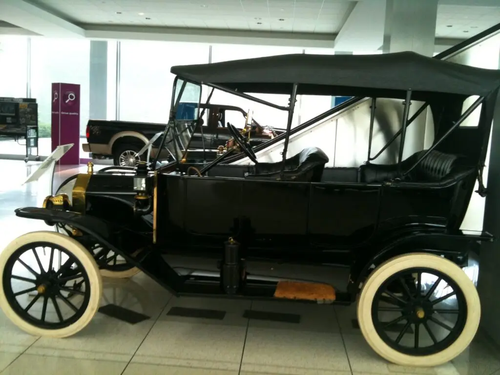 Side view of an early Ford automobile displayed at Ford Motor Company World Headquarters, showcasing the design and engineering of early twentieth-century motor vehicles.